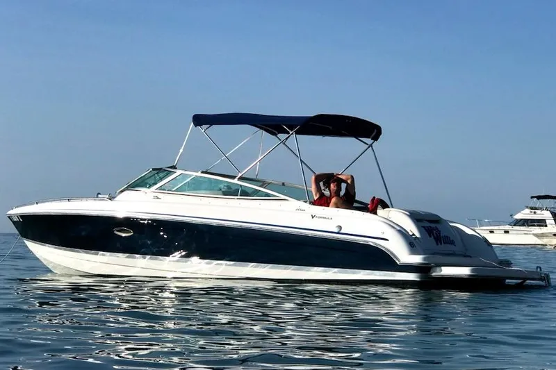 Slide: The Image of 2005 Formula 260 Bowrider boat on calm water with blue canopy. - 8