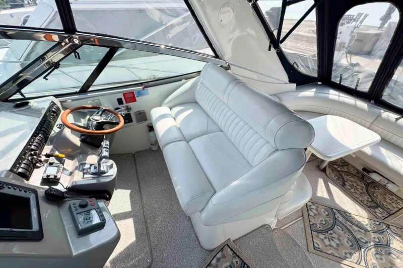 Slide: The Image of 2002 Cruisers Yachts 3870 Express helm with leather seating and modern controls. - 12