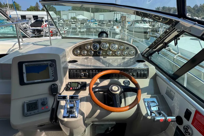 Slide: The Image of 2002 Cruisers Yachts 3870 Express helm with gauges, GPS, and wooden steering wheel. - 14