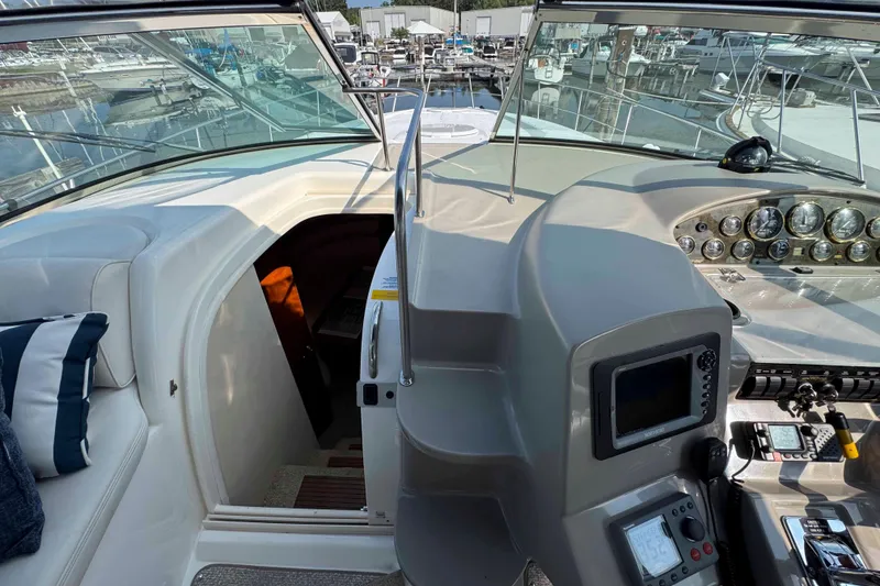Slide: The Image of 2002 Cruisers Yachts 3870 Express helm with navigation instruments and marina view. - 16