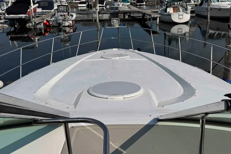 Slide: The Image of 2002 Cruisers Yachts 3870 Express boat deck at marina, surrounded by other boats. - 17