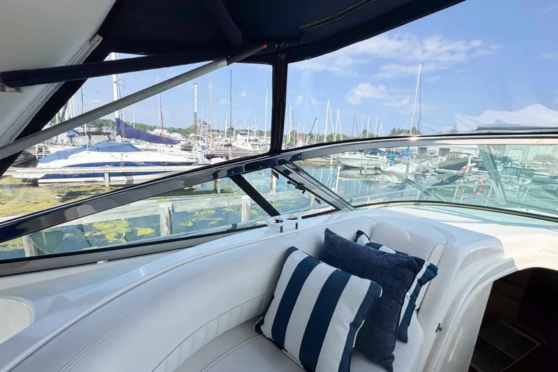 Slide: The Image of 2002 Cruisers Yachts 3870 Express interior with striped cushions, overlooking marina. - 18