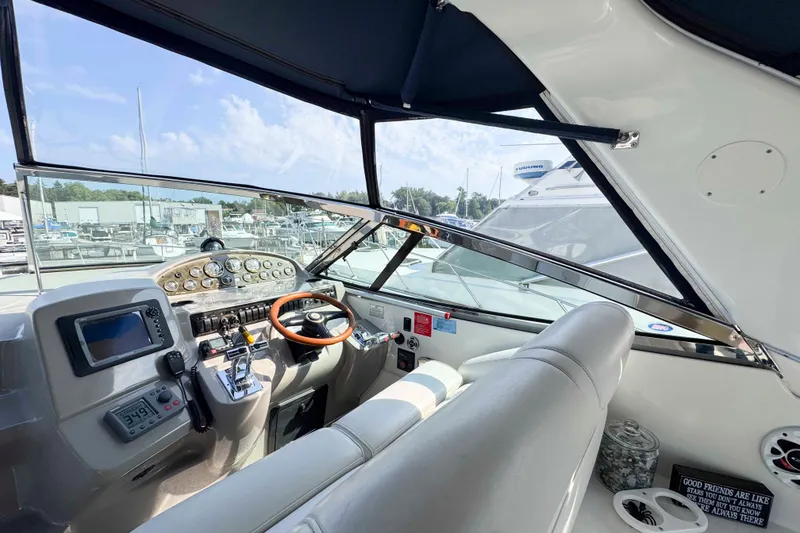 Slide: The Image of 2002 Cruisers Yachts 3870 Express helm with modern controls and panoramic marina view. - 21