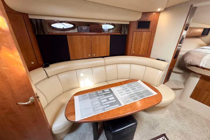 Slide: The Image of 2002 Cruisers Yachts 3870 Express interior with curved seating and wooden table. - 26