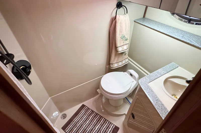 Slide: The Image of 2002 Cruisers Yachts 3870 Express bathroom with toilet, sink, and towel rack. - 32