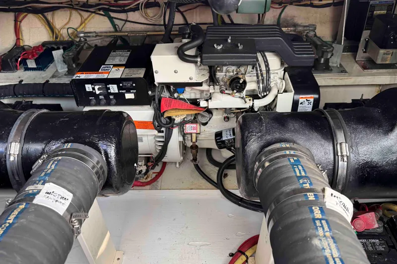 Slide: The Image of Engine compartment of a 2002 Cruisers Yachts 3870 Express, featuring mechanical components and wiring. - 34