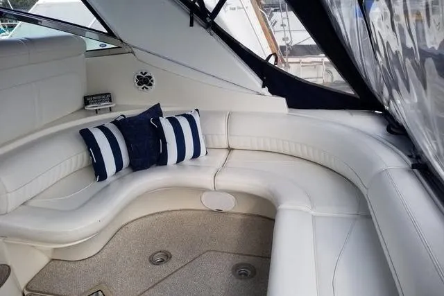Slide: The Image of 2002 Cruisers Yachts 3870 Express interior with white seating and striped cushions. - 4