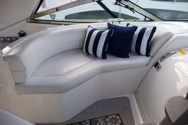 Slide: The Image of 2002 Cruisers Yachts 3870 Express interior with white seating and striped cushions. - 5