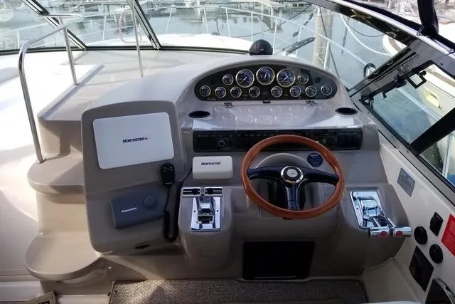 Slide: The Image of 2002 Cruisers Yachts 3870 Express helm with gauges, steering wheel, and controls. - 6