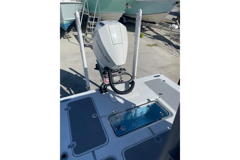 Slide: The Image of 2021 Young Boats Gulfshore 22 with outboard motor and livewell, parked near a fence. - 6
