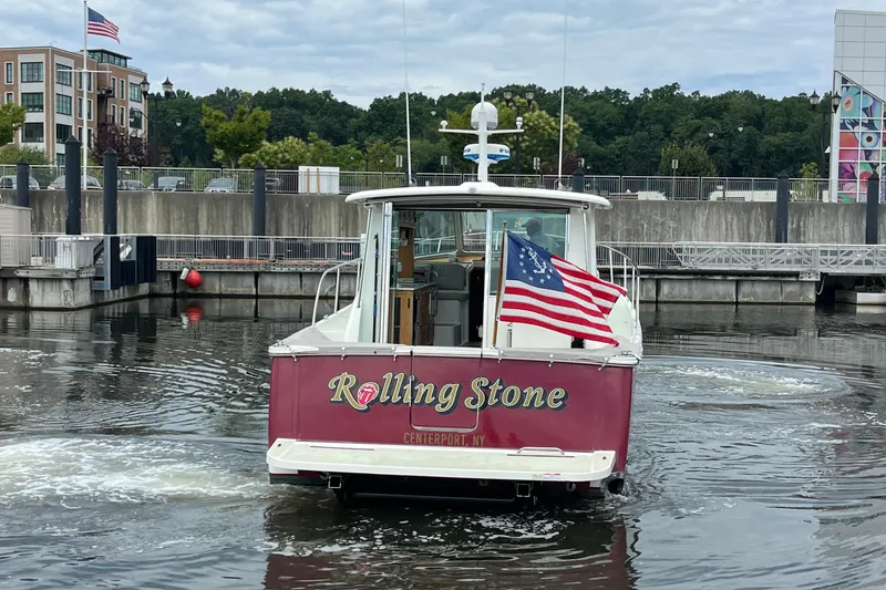 Slide: The Image of 2017 Back Cove 41 boat named "Rolling Stone" with American flag, docked in a marina. - 126