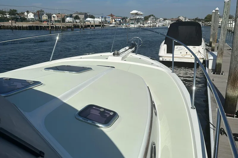 Slide: The Image of 2017 Back Cove 41 yacht docked at a marina, showcasing sleek design and spacious deck. - 14