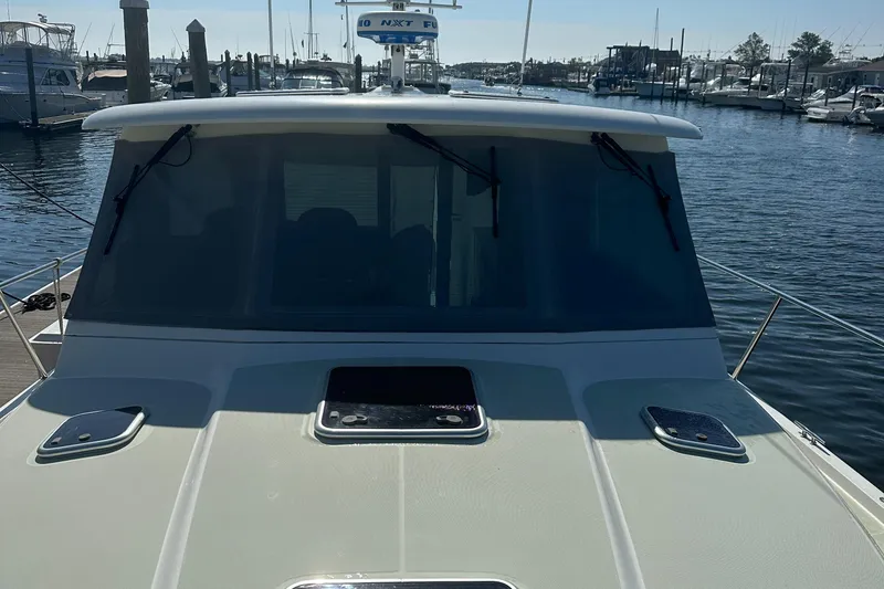 Slide: The Image of 2017 Back Cove 41 yacht docked at marina, front view with windshield and deck. - 16