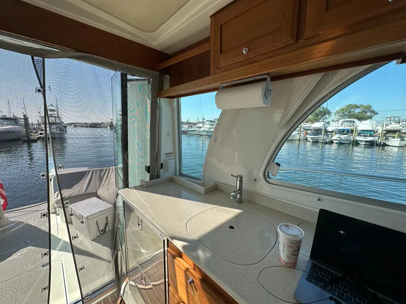 Slide: The Image of Interior of 2017 Back Cove 41 yacht with kitchenette, marina view, and outdoor seating area. - 30