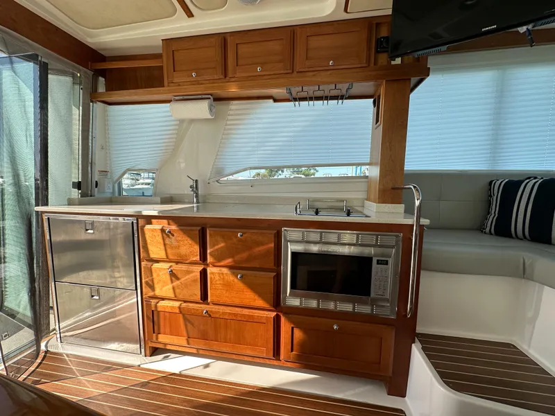 Slide: The Image of 2017 Back Cove 41 yacht interior with wooden cabinetry, kitchenette, and seating area. - 35