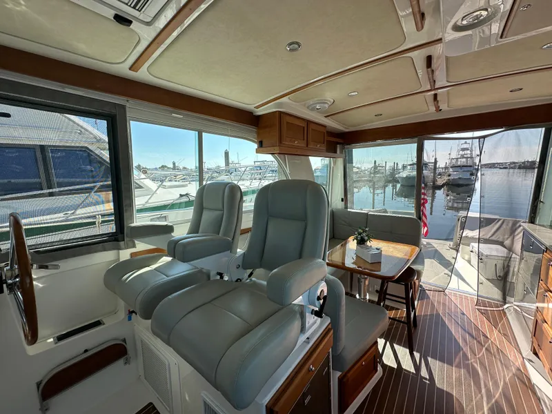 Slide: The Image of Luxurious 2017 Back Cove 41 yacht interior with plush seating and scenic marina view. - 42