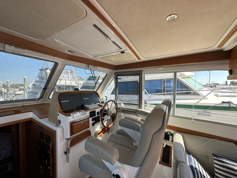 Slide: The Image of Interior of 2017 Back Cove 41 yacht with helm station and marina view. - 43