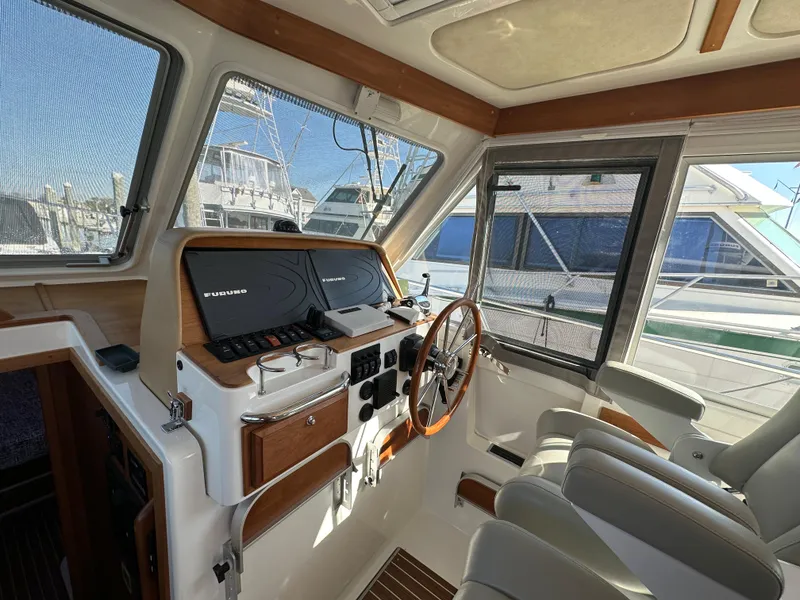 Slide: The Image of 2017 Back Cove 41 yacht helm with modern controls and comfortable seating. - 44