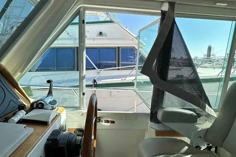 Slide: The Image of 2017 Back Cove 41 yacht interior with helm, overlooking marina and neighboring boat. - 46
