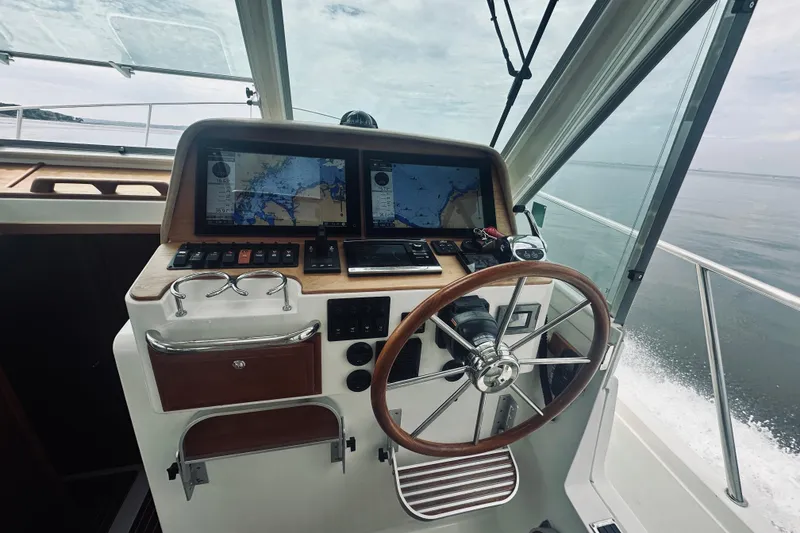 Slide: The Image of Helm of 2017 Back Cove 41 boat with navigation screens and steering wheel. - 50