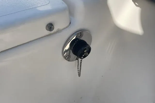 Slide: The Image of 2007 KenCraft 2260 BAYRIDER boat drain plug with chain on white surface. - 18