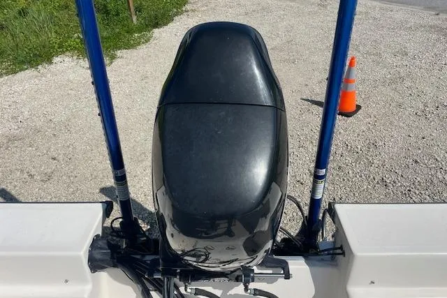 Slide: The Image of 2007 KenCraft 2260 BAYRIDER boat engine with dual blue poles on gravel surface. - 3