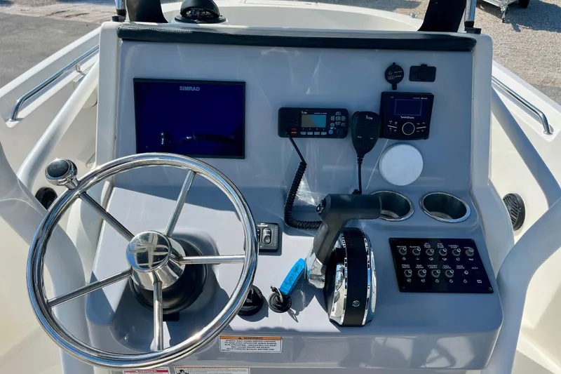 Slide: The Image of 2023 Trophy T24CC boat dashboard with steering wheel, controls, and navigation equipment. - 11