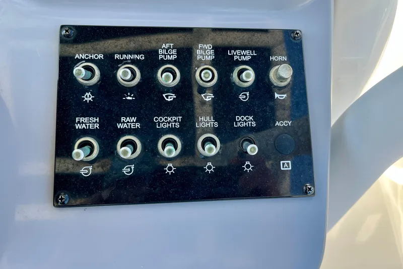 Slide: The Image of Control panel of 2023 Trophy T24CC boat with various switches and labels. - 14