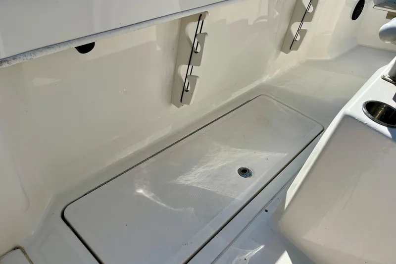 Slide: The Image of 2023 Trophy T24CC boat interior with storage compartment and rod holders. - 22