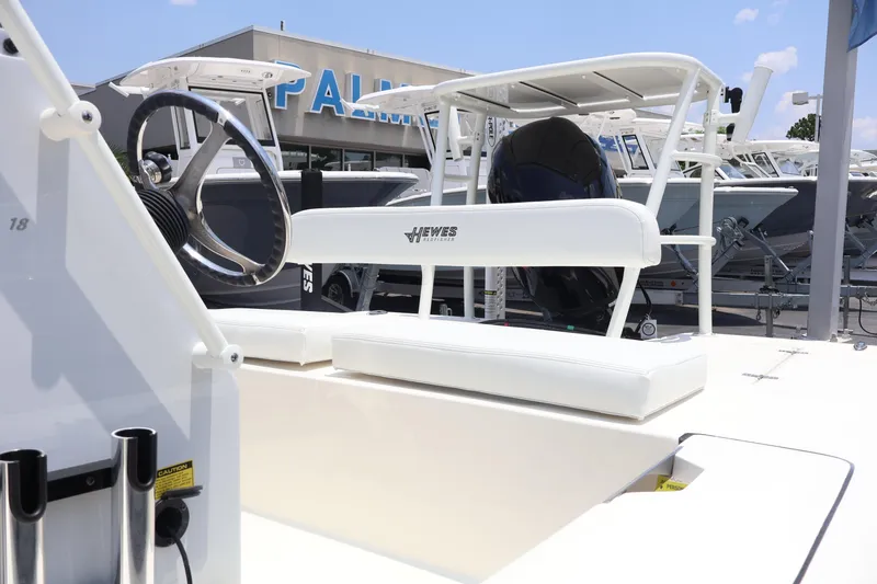 Slide: The Image of 2025 Hewes Redfisher 18 boat interior with steering wheel and seating at dealership. - 5