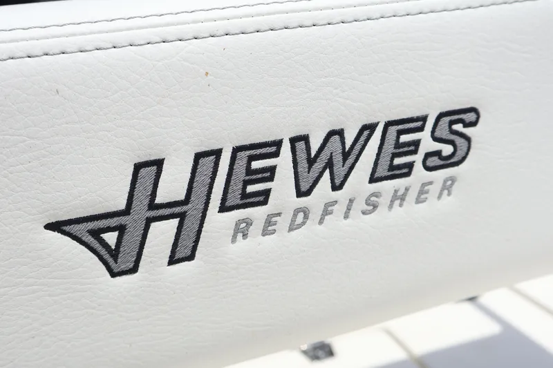 Slide: The Image of Hewes Redfisher 18 logo on white upholstery, 2025 model boat. - 6