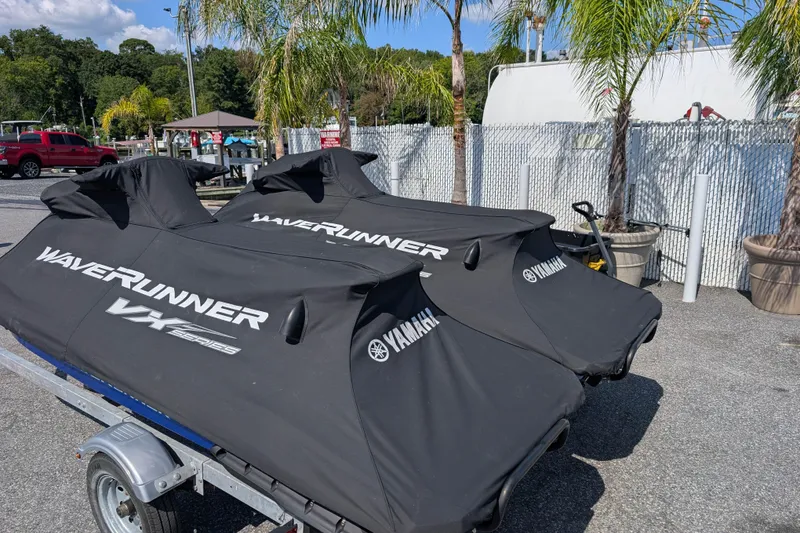 Slide: The Image of Covered 2021 Yamaha WaveRunner VX Deluxe jet skis on a trailer, parked near palm trees. - 16