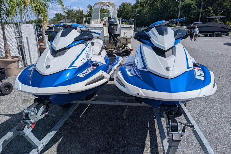 Slide: The Image of Two 2021 Yamaha WaveRunner VX Deluxe jet skis on a trailer in a parking lot. - 2