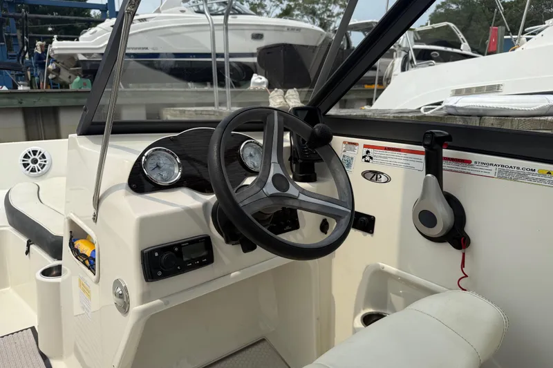 Slide: The Image of 2020 Stingray 192 SC boat dashboard with steering wheel and control panel. - 10