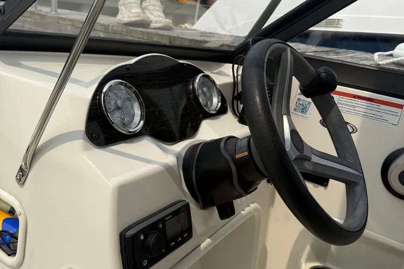 Slide: The Image of 2020 Stingray 192 SC boat dashboard with steering wheel and gauges. - 11