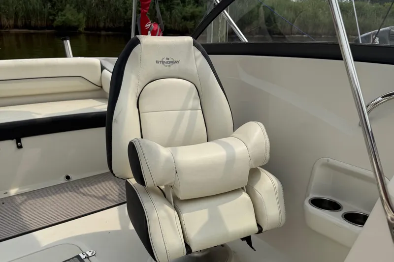 Slide: The Image of 2020 Stingray 192 SC boat interior with white captain's chair and cup holders. - 14