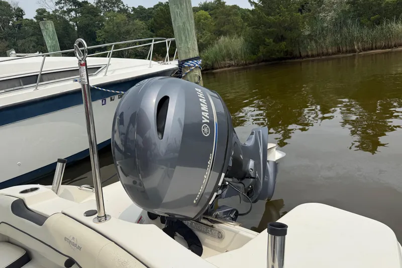 Slide: The Image of 2020 Stingray 192 SC boat with Yamaha outboard motor docked by a lake. - 15