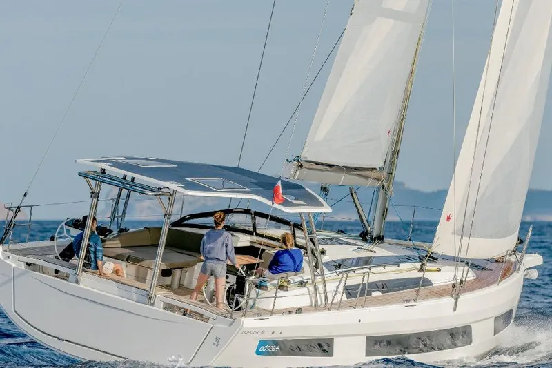 Slide: The Image of 2026 Dufour 48 sailing yacht cruising on open sea with passengers onboard. - 20
