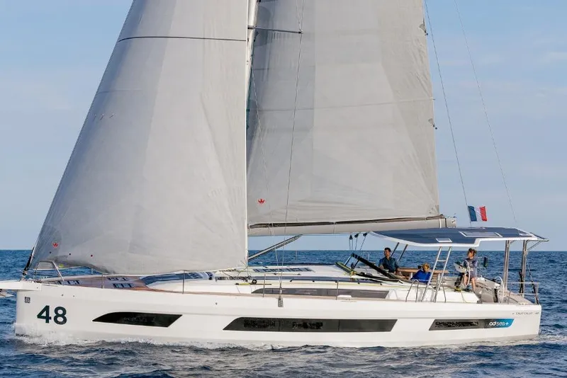 Slide: The Image of 2026 Dufour 48 sailing yacht on open sea with crew onboard. - 21