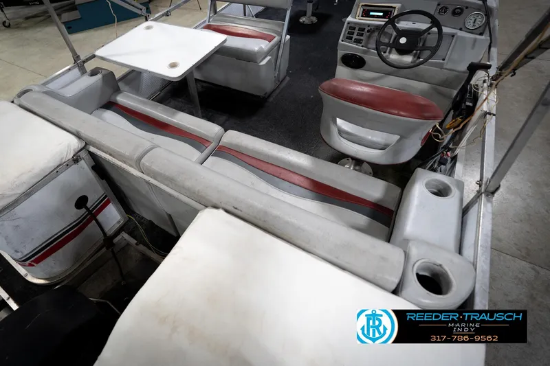 Slide: The Image of 1993 Godfrey Sweetwater boat interior with seating, steering console, and table. - 13