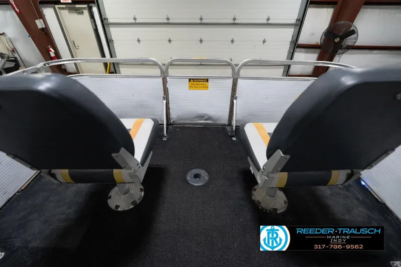 Slide: The Image of 1993 Godfrey Sweetwater boat interior with two seats, black carpet, and safety railing. - 17