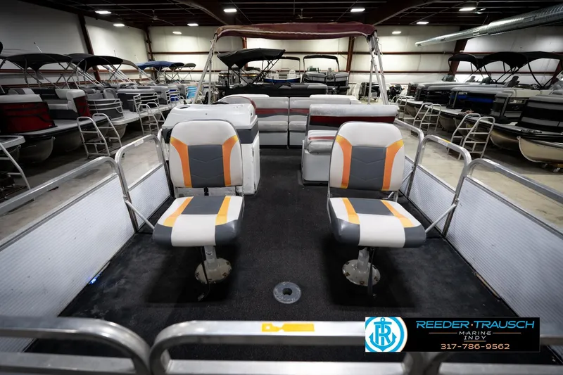 Slide: The Image of 1993 Godfrey Sweetwater pontoon boat interior with two-tone seating in a showroom. - 18