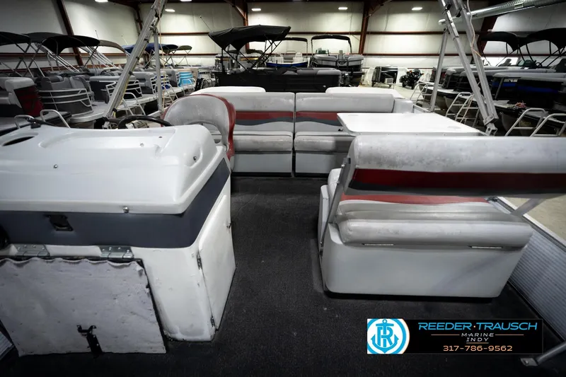Slide: The Image of 1993 Godfrey Sweetwater pontoon boat interior with seating and table in showroom. - 19