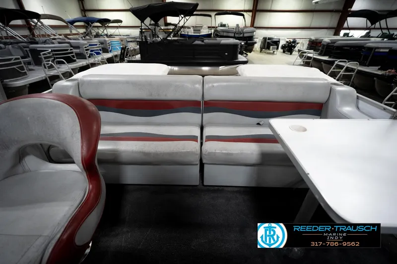 Slide: The Image of 1993 Godfrey Sweetwater pontoon boat interior with seating and table in showroom. - 20