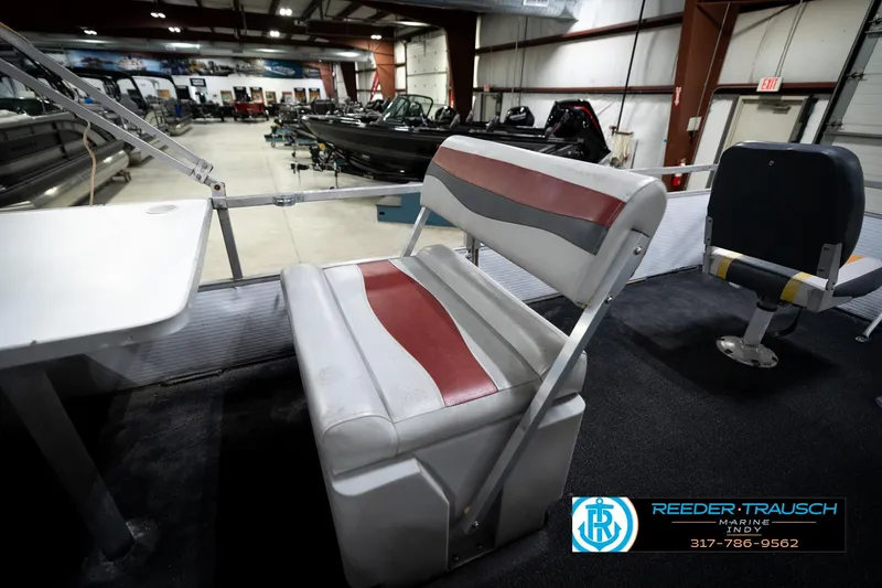 Slide: The Image of 1993 Godfrey Sweetwater boat interior with red and gray seating in showroom. - 23