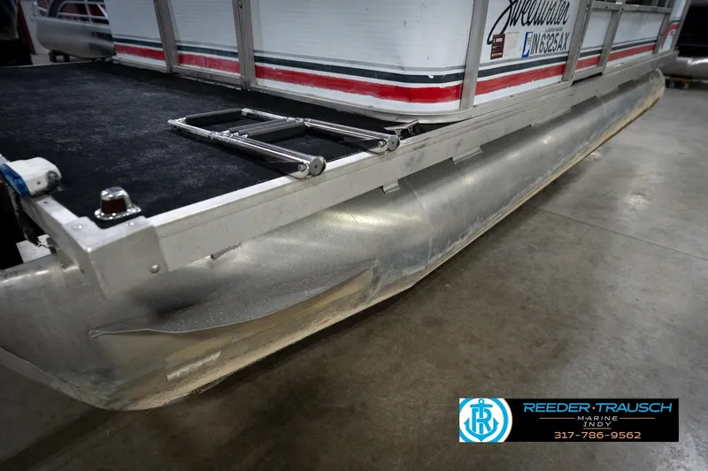 Slide: The Image of 1993 Godfrey Sweetwater pontoon boat with ladder, displayed indoors on concrete floor. - 25