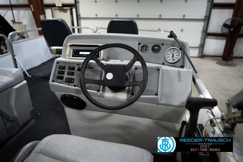 Slide: The Image of 1993 Godfrey Sweetwater boat dashboard with steering wheel and gauges in a garage setting. - 29