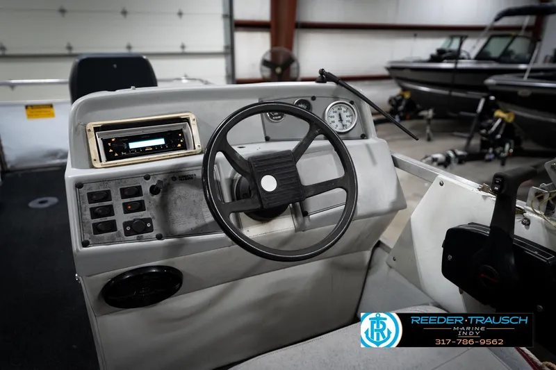 Slide: The Image of 1993 Godfrey Sweetwater boat dashboard with steering wheel and control panel in a showroom. - 30