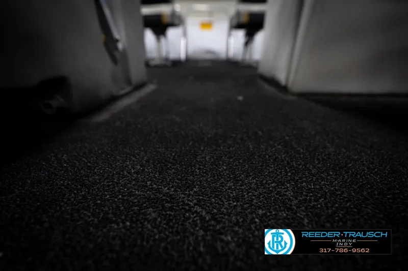 Slide: The Image of Interior view of a 1993 Godfrey Sweetwater boat with dark carpet flooring. - 43