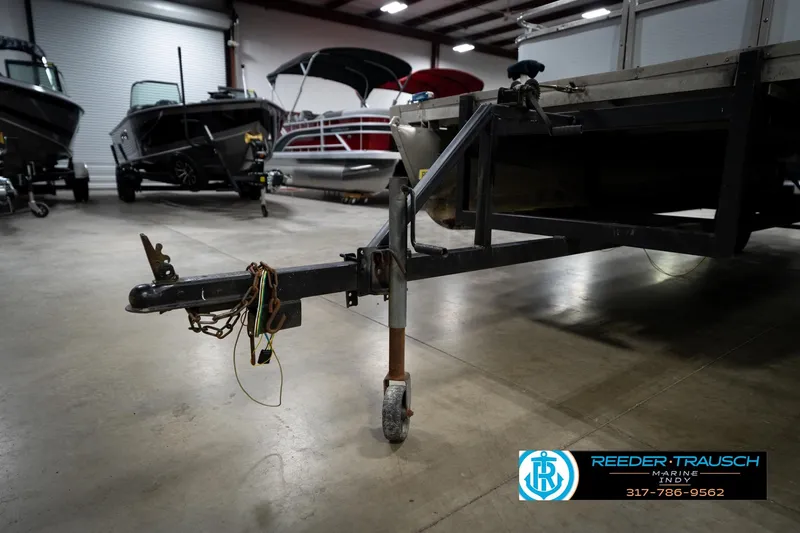 Slide: The Image of 1993 Godfrey Sweetwater boat trailer in a showroom with other boats. - 48